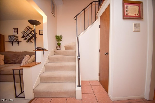 staircase featuring tile patterned flooring and baseboards