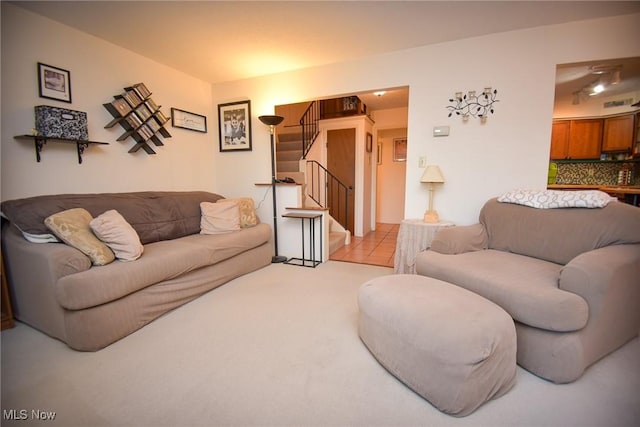 living room featuring light carpet and stairway