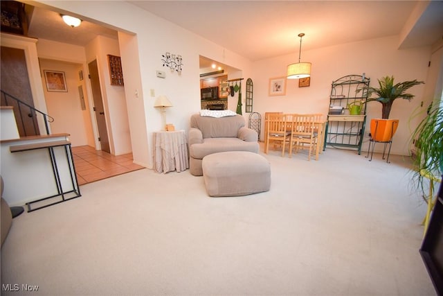 sitting room featuring carpet floors and stairs