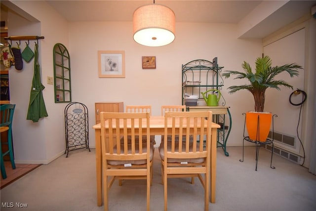 dining space featuring light carpet, visible vents, and baseboards