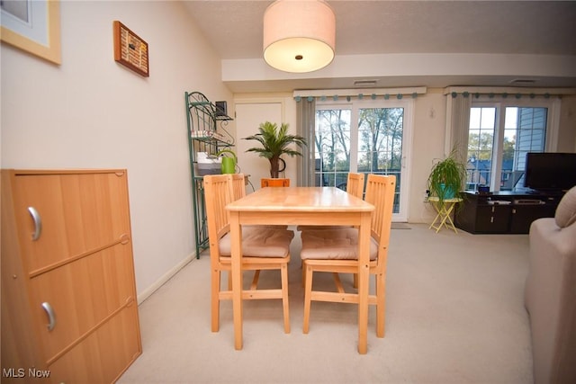 dining room featuring light carpet