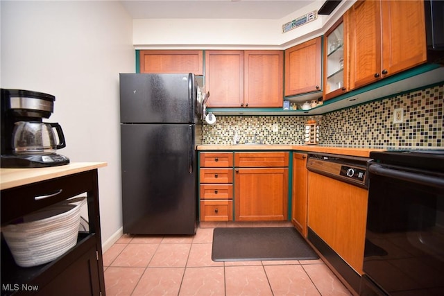 kitchen with light countertops, range, freestanding refrigerator, and decorative backsplash