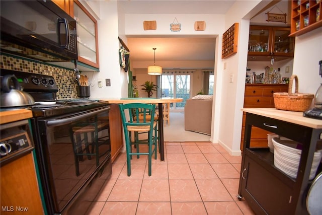 kitchen featuring light tile patterned floors, black appliances, tasteful backsplash, and light countertops