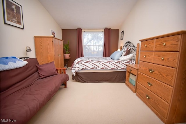 bedroom featuring lofted ceiling and carpet