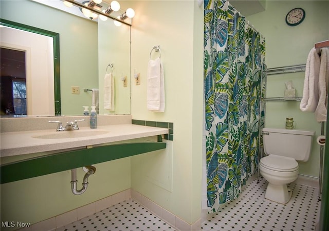 full bathroom featuring a shower with curtain, a sink, and toilet