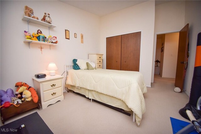 bedroom featuring a closet and light colored carpet