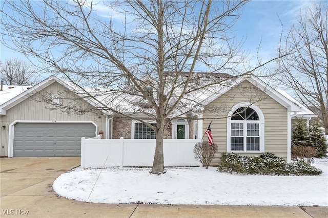 ranch-style house featuring a garage, driveway, and fence