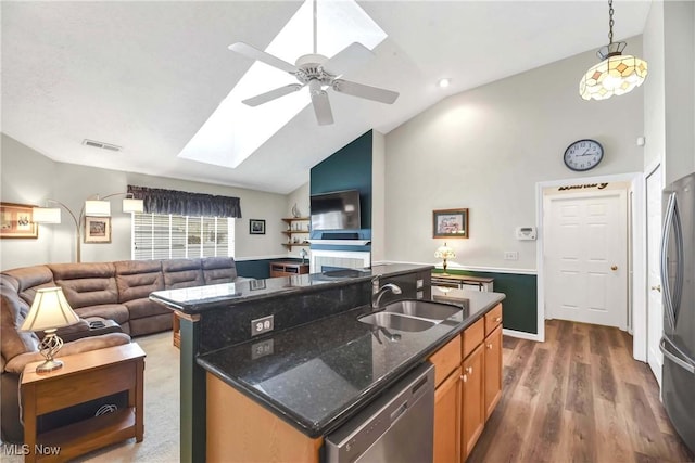 kitchen featuring appliances with stainless steel finishes, open floor plan, visible vents, and a sink