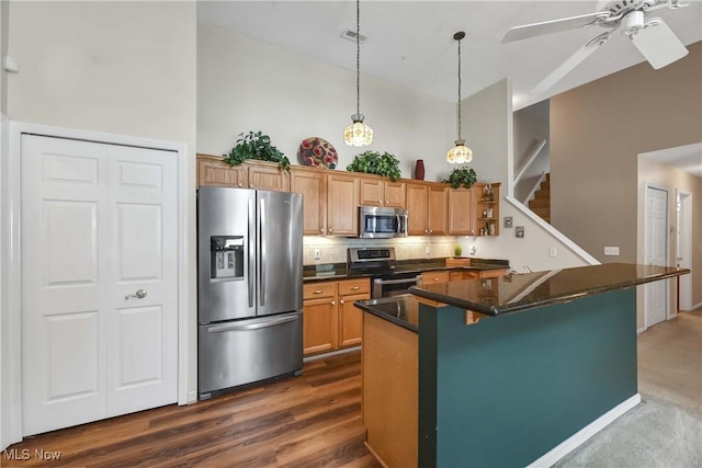 kitchen featuring stainless steel appliances, tasteful backsplash, hanging light fixtures, high vaulted ceiling, and a kitchen bar