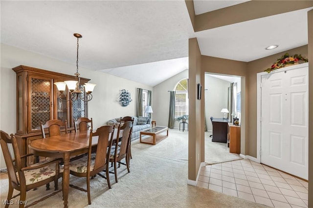 dining area with light carpet, light tile patterned floors, baseboards, lofted ceiling, and a chandelier