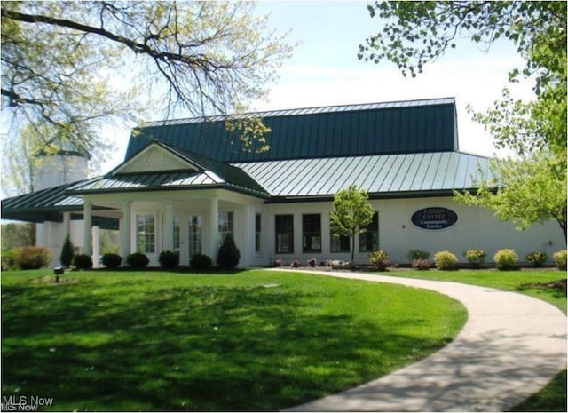 view of front of house with a standing seam roof, metal roof, and a front yard