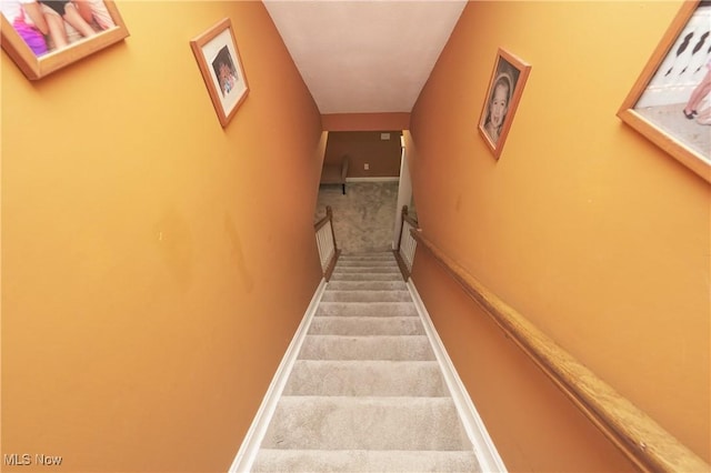 stairs featuring baseboards and carpet flooring