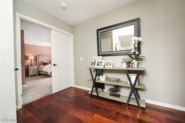 hallway with baseboards and hardwood / wood-style floors