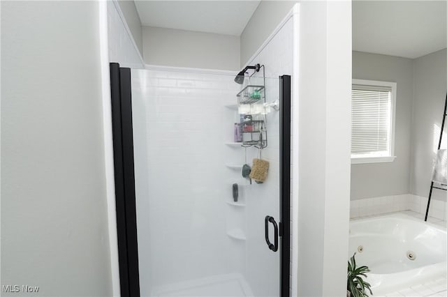 bathroom with a shower stall and a tub with jets