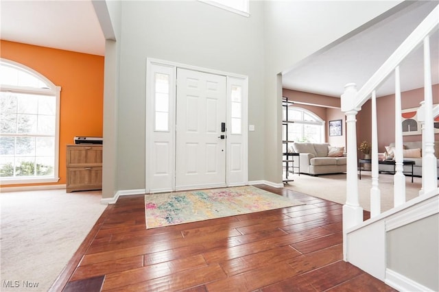 foyer entrance featuring baseboards, decorative columns, and hardwood / wood-style floors