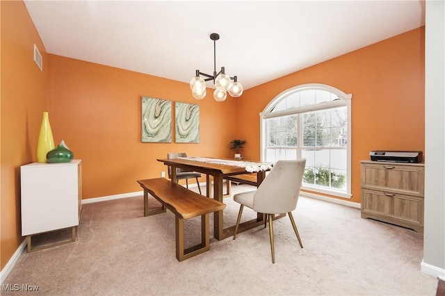 dining space with light carpet, a chandelier, visible vents, and baseboards