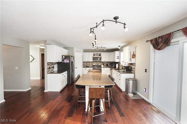 dining room with dark wood-style flooring and baseboards