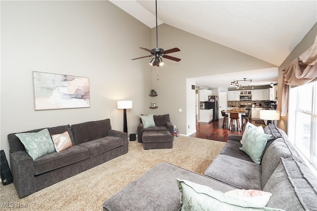 living room featuring high vaulted ceiling, a ceiling fan, and baseboards