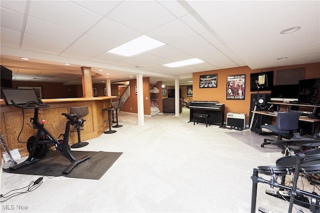 exercise room featuring carpet, a drop ceiling, and a bar