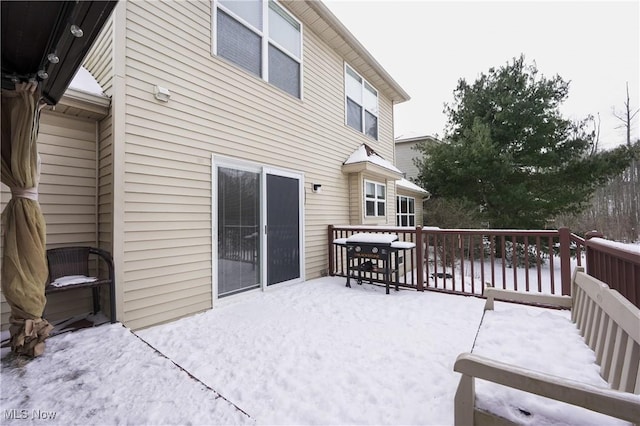 snow covered rear of property featuring a wooden deck