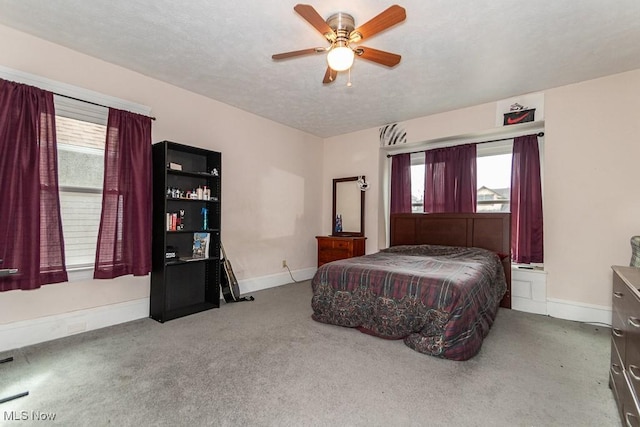 carpeted bedroom featuring a ceiling fan, baseboards, and a textured ceiling