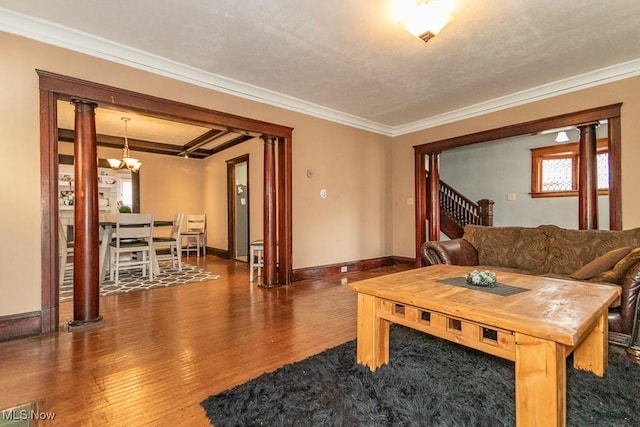 living area with ornamental molding, wood finished floors, decorative columns, and baseboards