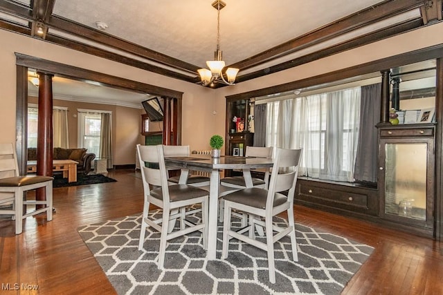 dining room featuring ornamental molding, dark wood-type flooring, a chandelier, and baseboards