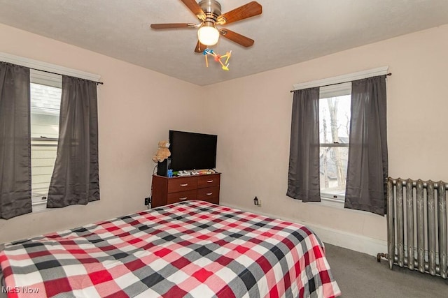 carpeted bedroom featuring radiator heating unit and ceiling fan