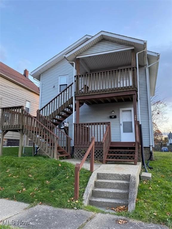 view of front of home with stairway and a front yard