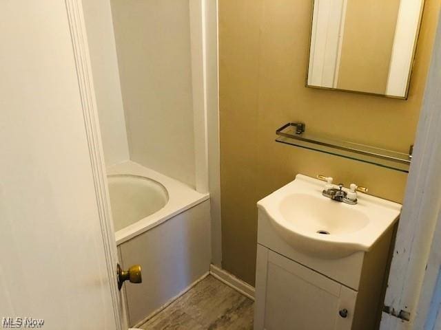 bathroom with a tub to relax in and vanity