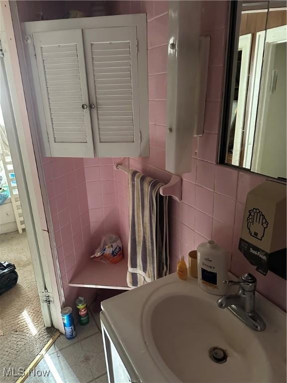 bathroom featuring a sink, tasteful backsplash, tile walls, and tile patterned floors