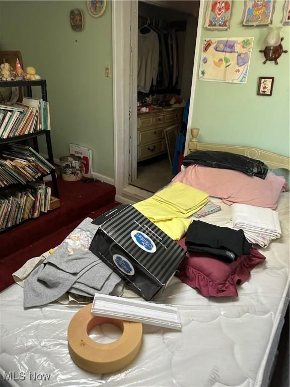 bedroom featuring baseboards and a closet