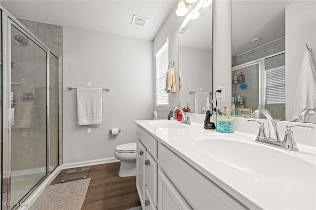 full bathroom featuring a shower stall, visible vents, a sink, and wood finished floors