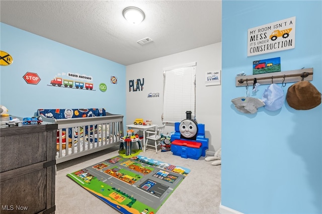 recreation room with carpet, visible vents, and a textured ceiling