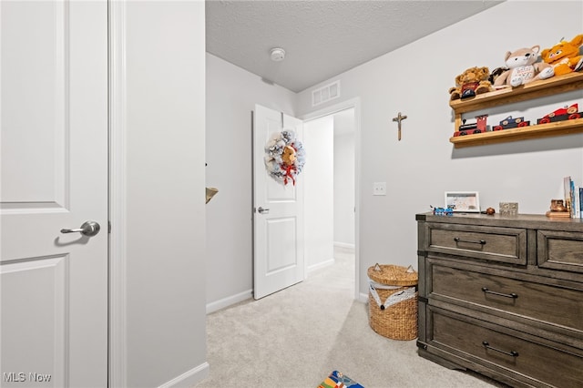 bedroom featuring light carpet, visible vents, baseboards, and a textured ceiling