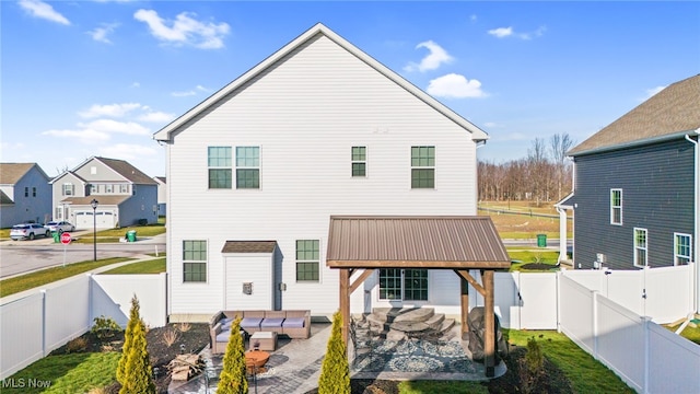 rear view of property with a patio area, a fenced backyard, a gate, and metal roof