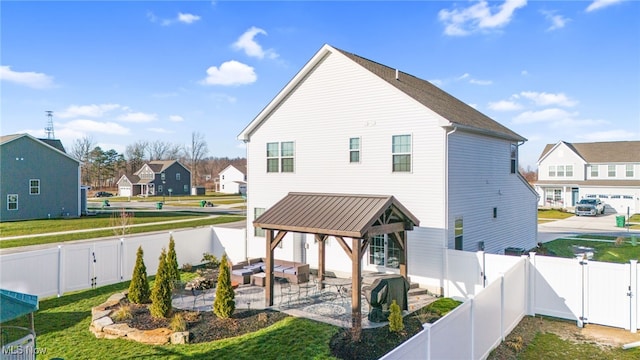 back of property featuring a yard, a patio, a gate, a residential view, and a fenced backyard