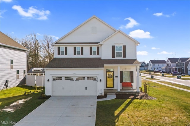 traditional-style house with a porch, a garage, fence, driveway, and a front yard