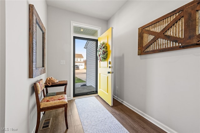 entryway featuring dark wood-type flooring, visible vents, and baseboards