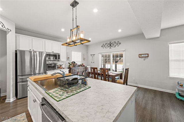 kitchen featuring light countertops, appliances with stainless steel finishes, a sink, and a wealth of natural light