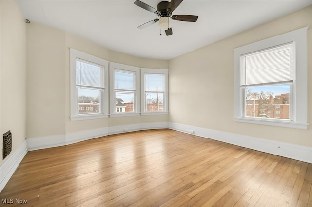 spare room featuring a ceiling fan, baseboards, and hardwood / wood-style flooring