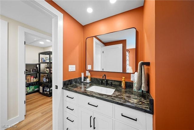 bathroom featuring recessed lighting, vanity, and wood finished floors