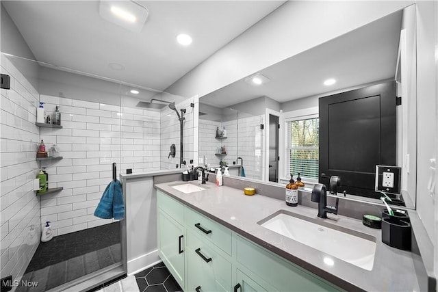 full bath with a tile shower, double vanity, a sink, and tile patterned floors