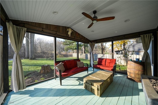 sunroom with ceiling fan and vaulted ceiling