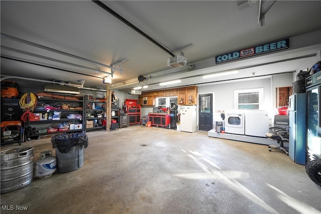 garage featuring a garage door opener, separate washer and dryer, a workshop area, and freestanding refrigerator