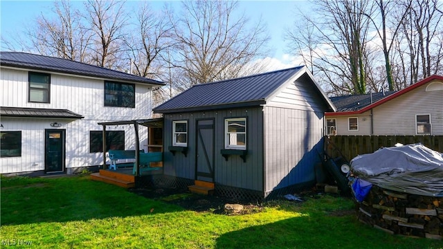 view of outdoor structure featuring fence and an outbuilding