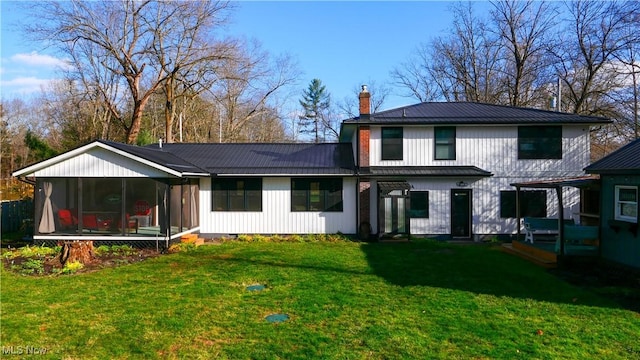 back of house with a lawn, a sunroom, a chimney, metal roof, and crawl space