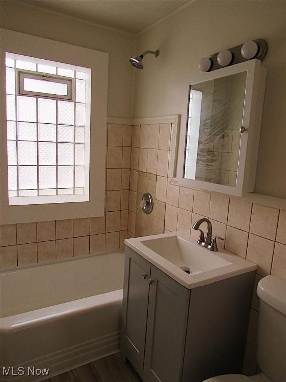 full bath featuring tile walls, decorative backsplash, toilet, vanity, and wood finished floors