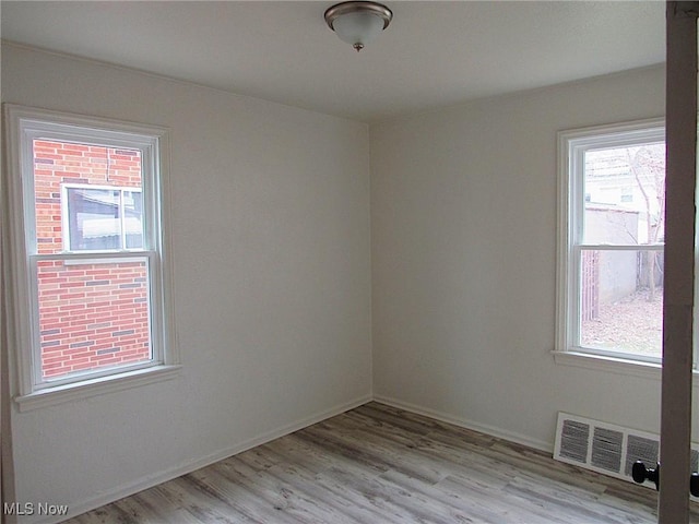 spare room with light wood-type flooring and visible vents