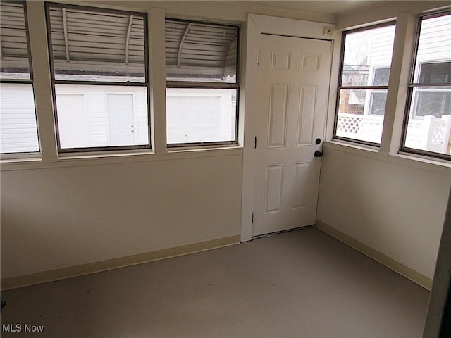 empty room with finished concrete floors and baseboards